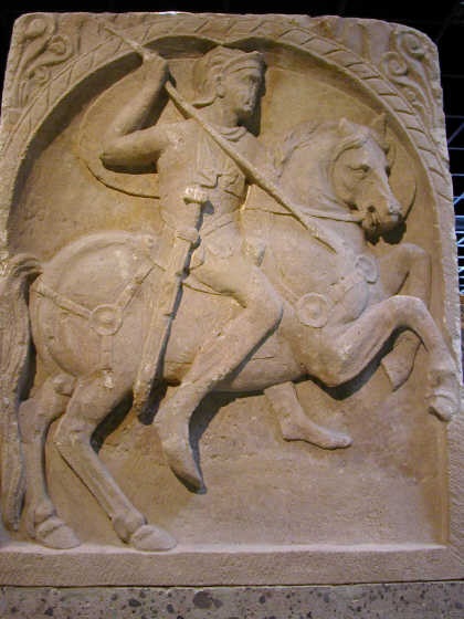 Náhrobní kámen zachycující římského jezdce v plné zbroji – s oštěpem a mečem, 1 století n. l.